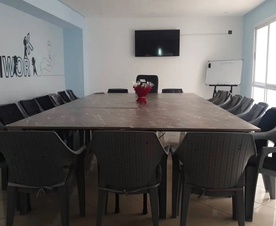 La salle de réunion et formation avec une grande table, un écran et un tableau blanc